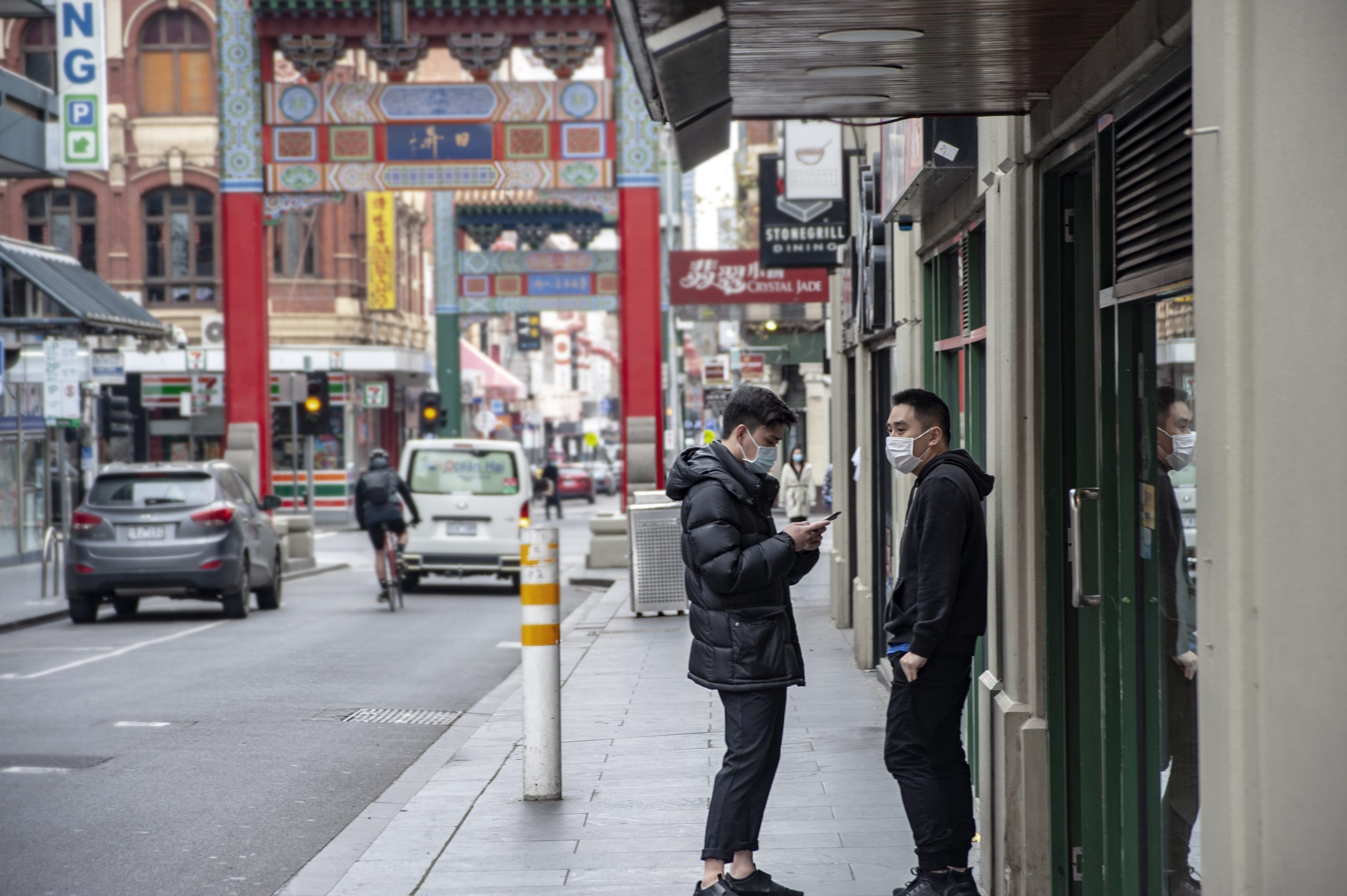 dwóch mężczyzn w maseczkach, na ulicach chinatown